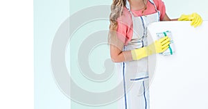 Woman in apron cleaning fridge against white and green background