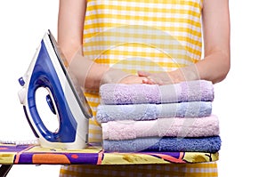 Woman in apron with iron ironing board towels laundry clothes