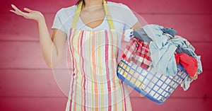 Woman in apron with laundry against blurry pink wood panel