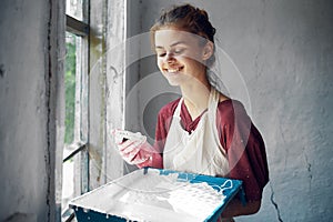 woman in apron painter repair painting window