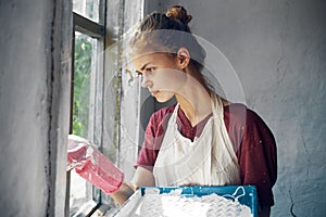 woman in apron painter repair painting window