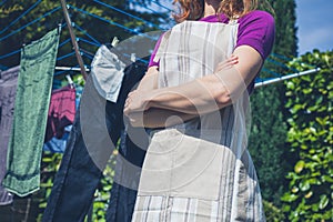 Woman in apron standing by clothes line