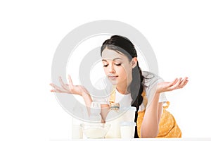 woman in apron with wide arms standing at table with children food and milk photo