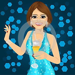 Woman in aqua sparkling dress holding a champagne glass