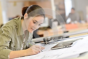 Woman architect drawing a plan at office photo