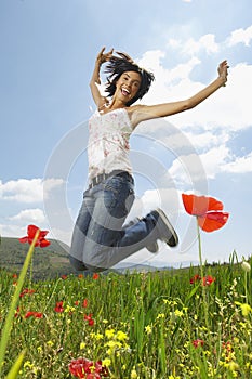 Woman With Arms Raised Jumping In Poppy Field