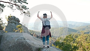 Woman with arms raised on top of mountain looking at view Hiker Girl lifting arm up celebrating scenic landscape