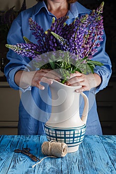 Woman arranges spring flower bouquet in a vase