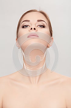 Woman with arrows on face over grey background. neck lifting con