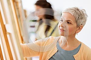 Woman artist with easel drawing at art school