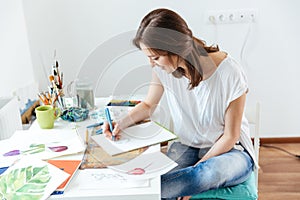Woman artist making sketches in workshop