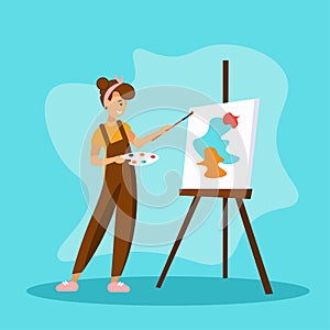 Woman artist painting abstract shapes on canva.She standing near easel and holding palette and brush