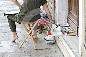 Woman artist painting on the street