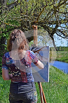 Woman artist painting summer landscape