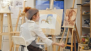 Woman artist painting watercolor picture in her studio photo