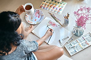 Woman artist paints and drinks tea