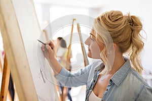 Woman artist with pencil drawing at art school