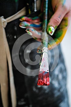 Una mujer artistas mano cepillar pintar. negro un delantal blanco 