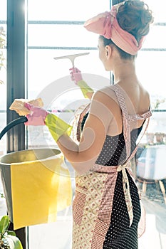 Woman as homemaker at spring clean working on the windows