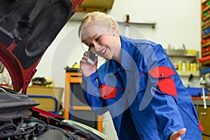 Woman as a mechanic in car workshop