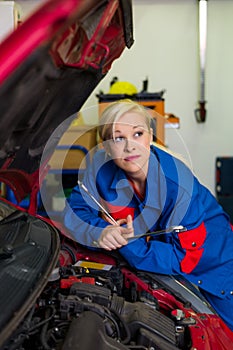 Woman as a mechanic in car workshop