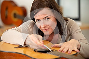 woman as trainee fixing guitar photo