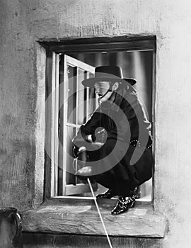 Woman as Zorro crouching in a window photo