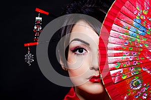 Woman in Asian costume with red Asian fan