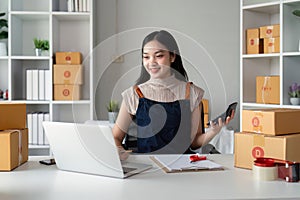 Woman asian in an online store check the customer address and package information on the laptop. Online shopping concept