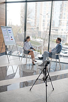 Woman asking her questions while interviewing successful businessman