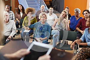 Woman Asking Question At Group Neighborhood Meeting In Community Center