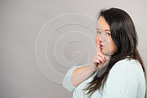 Woman asking for silence with finger on lips