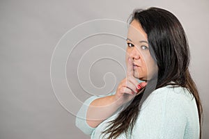 Woman asking for silence with finger on lips