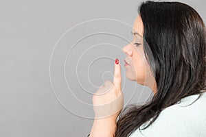 Woman asking for silence with finger on lips