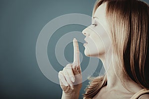 Woman asking for silence finger on lips