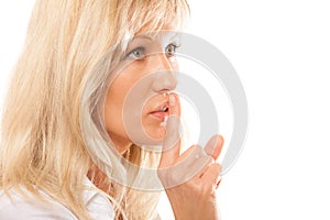 Woman asking for silence finger on lips hush gesture.