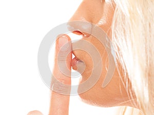 Woman asking for silence finger on lips hush gesture.