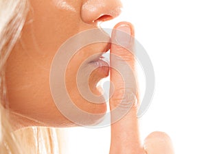 Woman asking for silence finger on lips hush gesture.