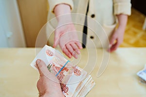 woman asks for stack of rubles tied with a rubber band.