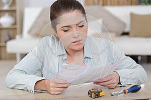 woman assembling pieces new furniture and reading instruction photo