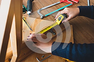 Woman assembly wooden furniture,fixing or repairing house with tape measures.modern living concepts