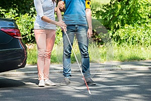 Woman Assisting Blind Man On Street