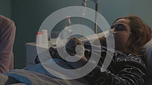 Woman assisting her daughter at the hospital and using her phone