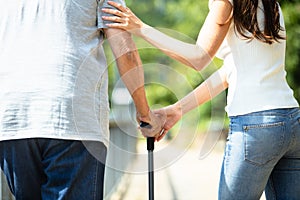 Woman Assisting Her Father While Walking