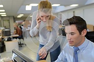 Woman assisting male computer clerk