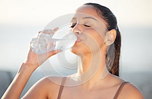 Woman, athlete and drinking water outdoors, thirsty and runner hydration after workout or cardio. Female person, detox