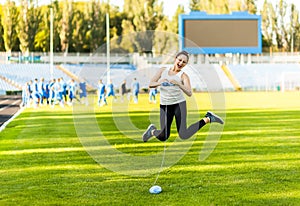 Woman athlete knitting a sweater on a football field