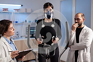 Woman athlete with mask doing fitness exercises in science sport lab