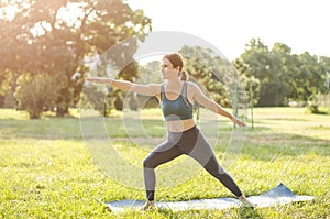 Woman athlete performs exercises in nature. Sports activities in nature. Woman doing sports exercises in the park