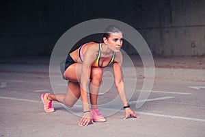 Woman athlete in the ready set go position to start running